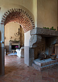 Fireplace next to arched, masonry doorway leading into living room