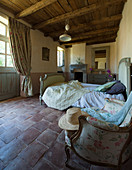 Terracotta floor tiles in French-style bedroom