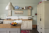 Country-house kitchen with beige panelled cupboards and island counter