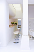 Dining area and open-plan kitchen in white, architect-designed house
