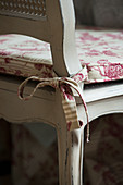 Patterned seat cushion tied to old wooden chair with bow