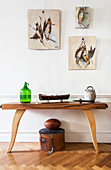 Pictures of shot birds above wooden console table