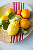 Citrus fruits on bamboo dish with colourful stripes