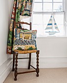 Brightly patterned curtain and cushion next to window