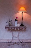 Table lamp and ornaments on metal console table