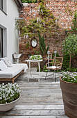 Inviting terrace adjoining house and exposed brick wall