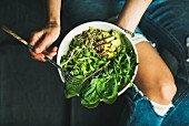 Vegane grüne Power-Bowl mit Spinat, Rucola, Avocado, Samen und Sprossen
