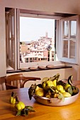 Pan holding quinces and view of city through window