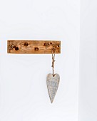Wooden love-heart hung from coat pegs