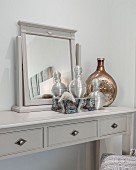 Mirror and elegant perfume bottles on grey dressing table