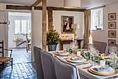 Festively set table in cottage with wooden beams and stone floor
