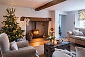 Christmas tree and fire in log burner in cosy living room