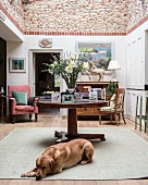 Dog lying on floor in front of table in classic interior