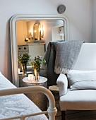 Exotic metal bedside table and armchair in front of mirror