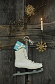 Christmas decoration and ice skate with present hung on wooden wall