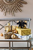 Presents glamorously wrapped in gold and blue on wooden bench
