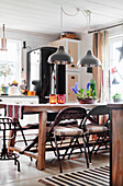 Folding metal chairs around wooden table in country-house kitchen