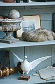 Stuffed dove and antique collectors items on shelves