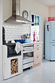 Old wood-fired cooker next to modern cooker and retro fridge