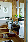 Doppelwaschtisch aus schwarzem Marmor, Holzstufen vor Badewanne in Chalet-Badezimmer