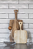 Glass carafe and wooden boards on countertop in front of wall tiles in the kitchen
