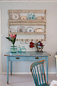 Vintage-style plates on plate rack above pale blue table