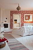 Wohnzimmer im skandinavischen Landhausstil mit Kamin und roter Tapete