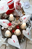 Original Advent arrangement made from numbered fabric hearts on wooden tray, paper stars, Christmas stocking and jars with fabric lettering