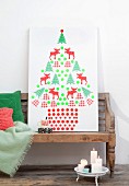 Stylised Christmas tree made from collage of cut-out silhouettes stuck on white panel
