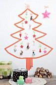 Christmas tree made from washi tape and various decorations stuck on white wall