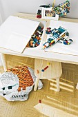 A child's play table with detachable panels and storage