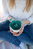 Woman holding potted paper succulent in hands