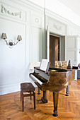 Grand piano in historical interior with panelled walls and parquet floor