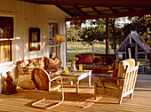 Sitzgruppe mit alten Möbeln auf der Veranda im gleißenden Sonnenlicht