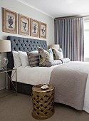 Double bed with button-tufted headboard and gilt side table in bedroom