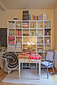 Set dining table in front of shelves of books and crockery