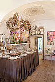Lavishly decorated dining table without chairs below vaulted ceiling