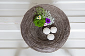 Dish made from corrugated cardboard decorated with natural arrangement of flowers and moss