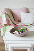 Dish on nest of side tables in front of white sofa with patchwork blanket