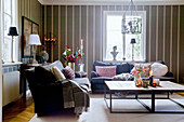 Cosy living room in shades of grey with striped wallpaper