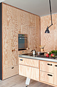Open-plan fitted kitchen with plywood cupboards and island counter