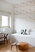 Patterned retro wallpaper in small bedroom in shades of white and brown
