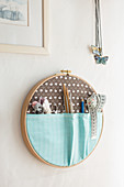 Organiser for sewing utensils in embroidery frame on wall