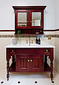 Antique washbasin made of reddish wood with matching mirror cabinet