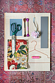 Mood board of floral fabric and wooden sewing utensils