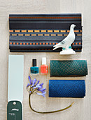 Mood board with fabric swatches, nail polishes, flower and bird figurine