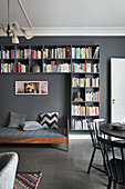 Day bed frames by bookshelves on grey wall