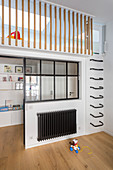Wall-mounted ladder rungs leading to mezzanine in child's bedroom