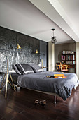 Double bed against black wall relief in bedroom