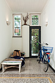 Blue bicycle and sun lounger in foyer with terrazzo floor